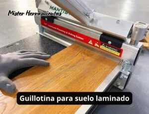 Guillotina para suelo laminado realizando un corte limpio sobre una tabla de tarima flotante