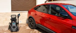 Cecotec HydroBoost 2400 AdvanceClean junto a un coche rojo en el patio